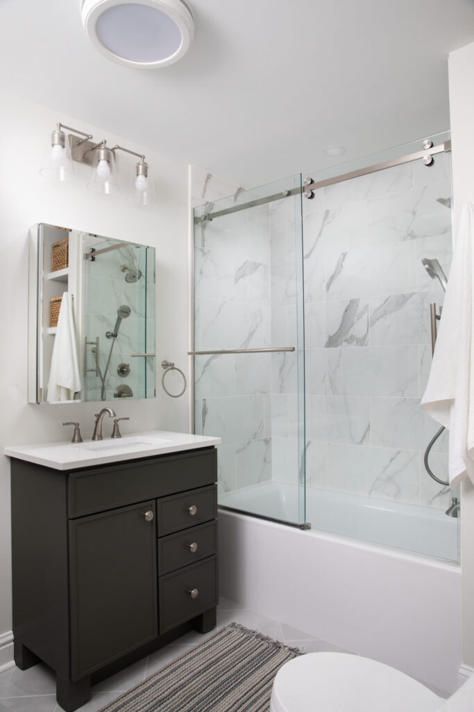 An updated bathroom with white marble tiles